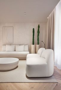 Salón en tonos blancos y líneas puras del espacio Sofía Oliva Arquitectura en Casa Decor 2021, ejemplo de interiorismo luminoso y acogedor.