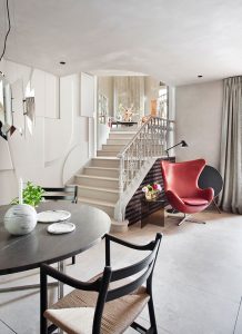 Sillón Egg de Arne Jacobsen en un rincón de lectura bajo la escalera de piedra del espacio Danish Design Plus, diseñado por Erico Navazo para Casa Decor Madrid 2021.
