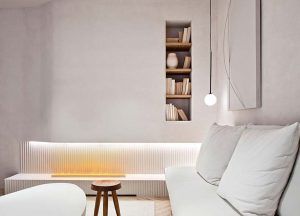 Salón minimalista en tonos blancos con iluminación cálida e interiorismo eficiente, ejemplo de diseño acogedor para invierno en estilo contemporáneo.