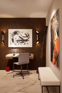 Pequeño despacho integrado en el recibidor, con pared de listones de madera, diseño de Espacio Óvalo en Casa Decor 2023.