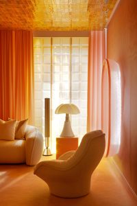 Lámpara Pipistrello de Gae Aulenti en el espacio Bang & Olufsen, diseñado por Miriam Alía para Casa Decor 2023, con mobiliario de formas curvas y decoración en tonos cálidos.