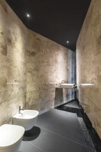 Espacio Roca Casa Decor 2025, Baño revestido en mármol Xtone en Casa Decor 2025, con paredes de piedra en gran formato, lavabo suspendido y sanitarios de líneas minimalistas.