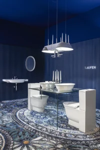 Instalación de baño azul diseñada por Marcel Wanders para Laufen en Casa Decor 2025, con lavabos escultóricos y alfombra ornamental.
