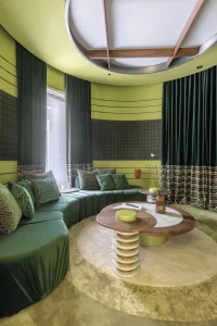 Espacio Bang & Olufsen Atelier Art Gallery de Jose Lara en Casa Decor 2025, sala circular en tonos verdes con textiles cálidos y diseño envolvente.
