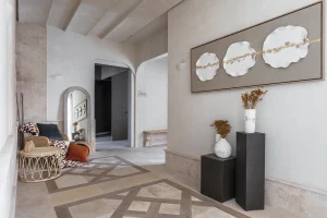 Entrada con pavimento geométrico y paredes en tonos neutros, proyecto del estudio Wink en Casa Decor 2025