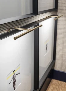 Apliques de pared Corston con acabado metálico en el Espacio Technogym de Casa Decor 2025, herrajes e iluminación de diseño atemporal y precisión técnica.