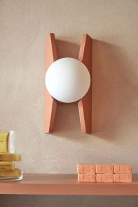 Primer plano del aplique decorativo en pared revestida en arcilla natural, aportando carácter al diseño interior