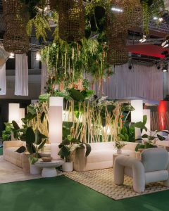 Zona de sofás y sillones curvos en el Kissing Room de Raúl Martins, diseño de interiores con vegetación exuberante y luz ambiental cálida.