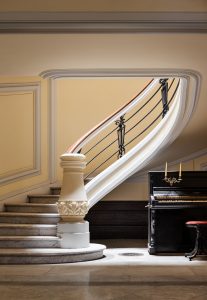 Escalera monumental del interior de la Casa Palacio del Marqués de los Vélez con diseño art déco y vidriera histórica