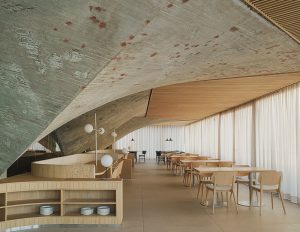 Restaurante del Museo Marítimo del Cantábrico diseñado por Zooco Estudio, interior con estructura de hormigón y techos de madera