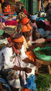 Mujeres senegalesas participando en un proyecto de autonomía económica de Kassumay, preparando alimentos en un entorno comunitario.