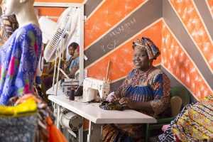 Mujer trabajando en un taller de costura promovido por Kassumay, proyecto de formación y generación de empleo para mujeres en Senegal.