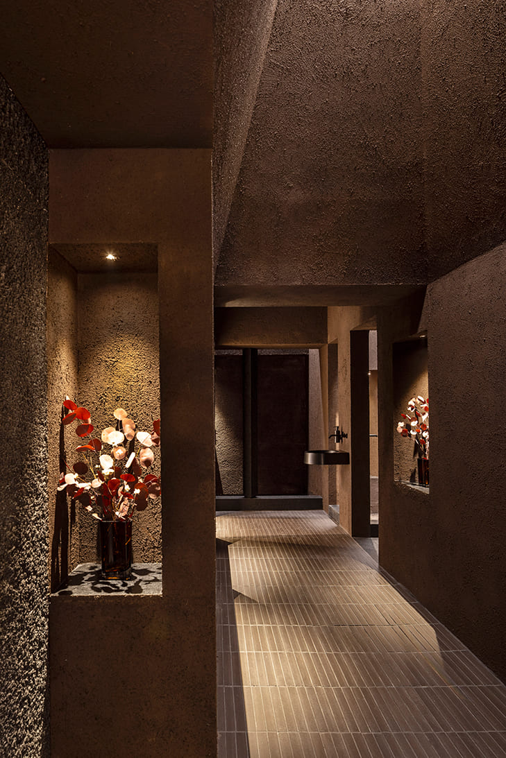 Baño Espacio Laufen en Casa Decor con iluminación Arkoslight, focos empotrados Nano y apliques Rec Micro Rec destacando texturas en tonos oscuros