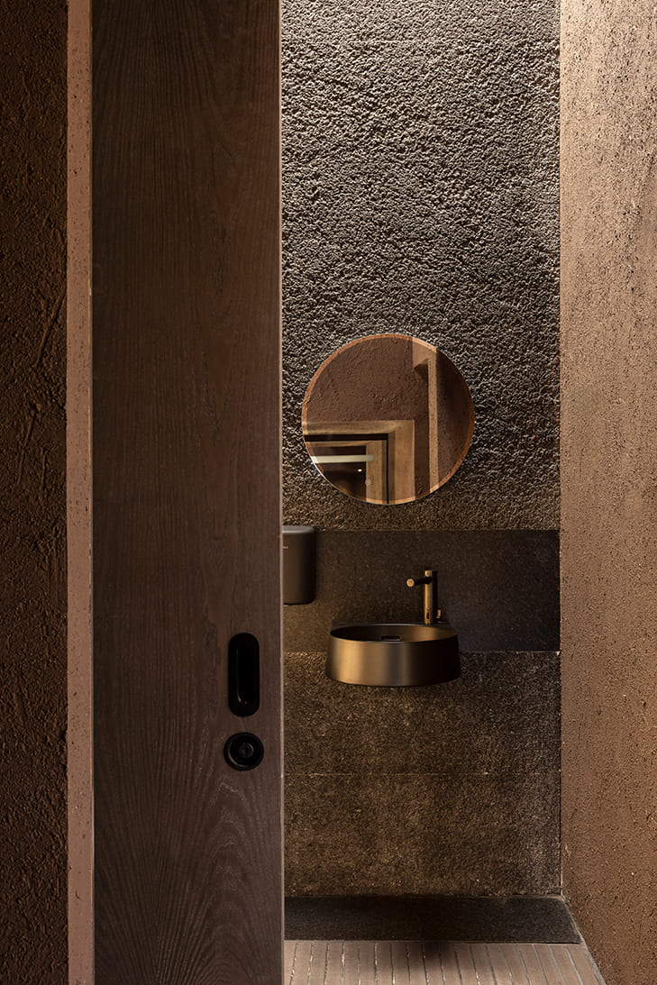 Puerta corredera de madera de fresno tintado de Proma en espacio Laufen Casa Decor 2026, carpintería minimalista integrada