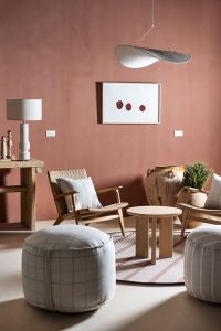 Zona de conversación con butacas de diseño nórdico, pufs tapizados y mesa redonda en el espacio KASBAH de ARCOmadrid