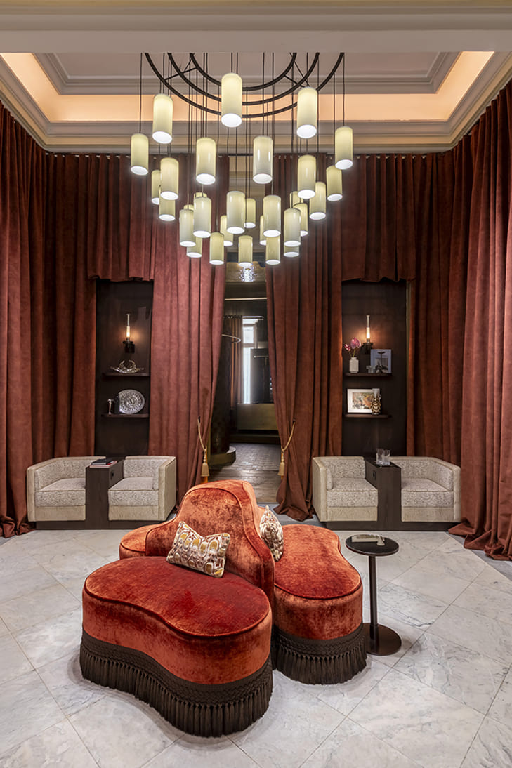 Asiento Borne Sette en terciopelo rojo con mesas auxiliares Tempo en lobby bar diseñado por Nost para Casa Decor 2026 con mobiliario Fama