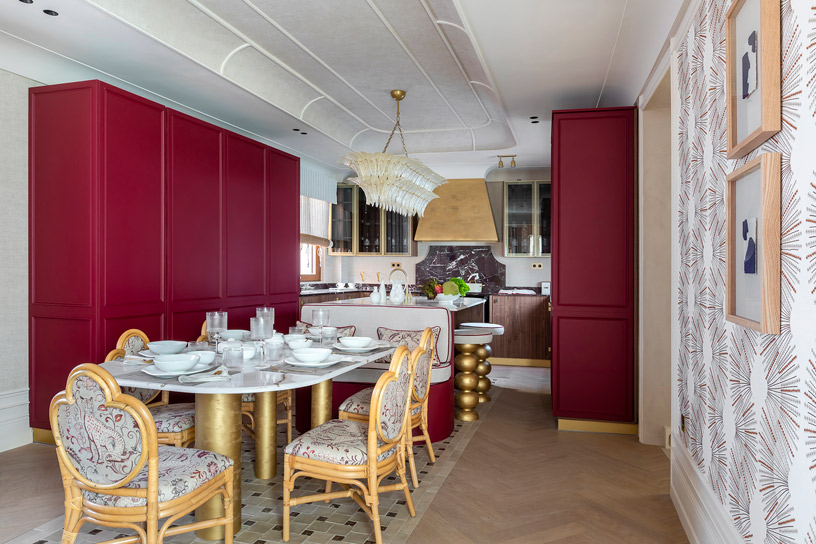 Cocina clásica contemporánea “Cuisine Bourgogne Dorée” con gran isla central, acabados dorados, papel pintado decorativo y suelo cerámico estilo mediterráneo.