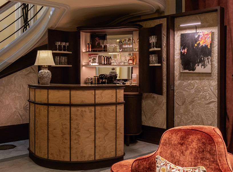 Mueble bar y biombo diseñados por estudio Nost con papel pintado Allures Éclosion bordado sobre algodón y decoración en madera oscura en Casa Decor 2026