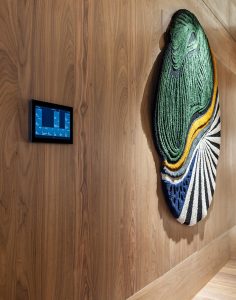 Paneles de nogal Davos de Schotten & Hansen con tecnología Niessen integrada y pieza textil tridimensional de AITEX en The Listening Bar.
