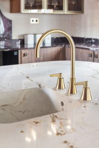 Grifería Ramonsoler Adagio en acabado dorado sobre encimera de mármol en la cocina Trae de Casa Decor 2026