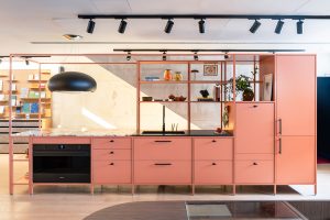 Cocina Kitchen for Life en tono terracota con horno integrado, estanterías abiertas y frente modular