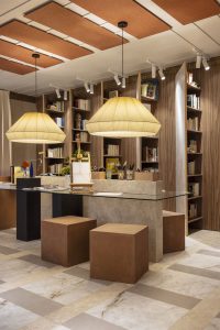 Espacio con paneles acústicos decorativos suspendidos en el techo y lámparas de fibras