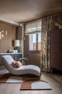 Salón con revestimiento efecto madera continuo de pared a techo en Casa Decor 2026