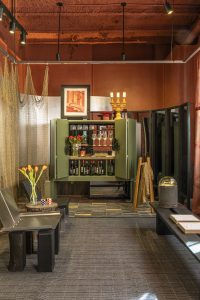 Mueble bar verde diseñado por TARQ Studio para Dos Latitudes, con encimera Neolith y objetos artesanales