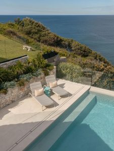 Piscina con vistas al mar y pavimento Dekton Albarium en una casa de diseño en Port Kembla