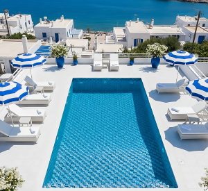 Piscina con mosaico Hisbalit azul en terraza blanca de estilo mediterráneo