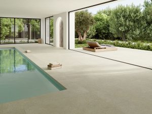 Pavimento Neolith continuo entre interior, terraza y piscina en una vivienda contemporánea
