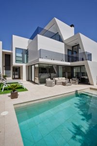 Piscina exterior de vivienda moderna con pavimento Neolith resistente al agua y al sol