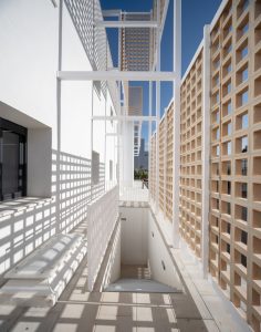Pasarela del edificio CICYTEX protegida por celosías cerámicas que proyectan sombras