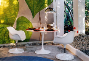 Comedor de jardín diseñado por Clementina Lizcano y Franc Berrizbeitia para Casa Decor Barcelona 1999, con mesa Tulip de Eero Saarinen, sillones blancos a juego y lámpara Arco de los hermanos Castiglioni.